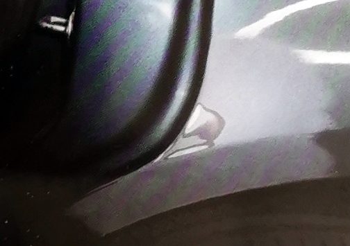 Beschädigte Kante an der Tür eines grauen Autos